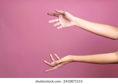Woman hands holding or giving something big like bag or gift box over pink background 库存照片