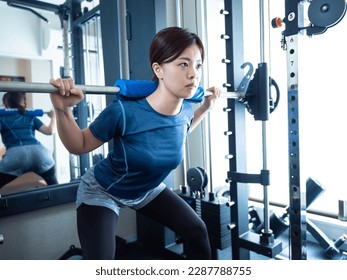 Woman squatting on power rack Foto stock