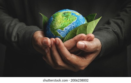 World Earth Day Concept. Green Energy, ESG, Environmental, social and corporate governance. Renewable and Sustainable Resources. Environmental and Ecology Care. Hand Embracing Green Leaf and Globe: stockfoto