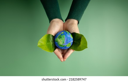 World Earth Day Concept. Green Energy, ESG, Renewable and Sustainable Resources. Environmental and Ecology Care. Hands of Person  Embracing Green Leaf and Craft Globe Stock Photo