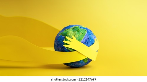 World Earth Day Concept. Green Energy, ESG, Renewable and Sustainable Resources. Environmental Care. Paper Cut as Hands Embracing Green Globe. Hug and Cherish the World Stock Photo