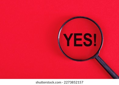 Yes word through magnifying glass on red background.: zdjęcie stockowe