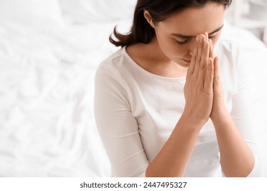 Young woman praying in bedroom, closeup: stockfoto