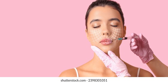 Young woman receiving filler injection in face against pink background with space for text. Skin care concept Stockfotó