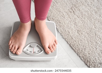 집에서 저울에 서 있는 젊은 여자. 체중 감량 개념 스톡 사진