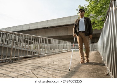 Young blind man walking in city with walking stick. Visually impaired man difficult to traveling on the road wearing sun glasses Cross the road cross the footbridge – Ảnh có sẵn