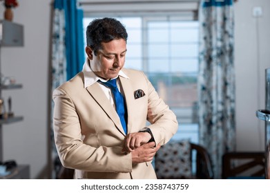 Young businessman in formal suit getting ready for office and checking his smart watch  Adlı Stok Fotoğraf