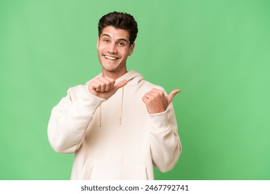 Young caucasian handsome man over isolated background pointing to the side to present a product Foto stock