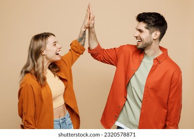 Young fun happy couple two friends family man woman wear casual clothes together meeting together greeting giving high five clapping hands folded isolated on pastel plain light beige color background Foto stock