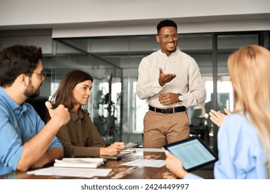 Young happy African American male executive company leader discussing project management planning strategy working with diverse busy colleagues company team at office corporate board group meeting. Stockfoto