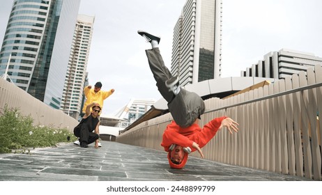 Young happy hipster perform break dancing or foot step with friend moving to hiphop music together. Skilled dancer doing freeze pose and waving hand. Modern lifestyle. Outdoor music 2024. Sprightly. Foto stock