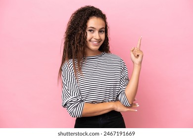 Young hispanic woman isolated on pink background happy and pointing up Foto stock
