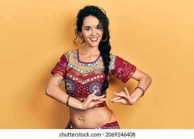 Young indian woman wearing traditional belly dancer costume. Dancing exotic oriental dance with body and hands: stockfoto