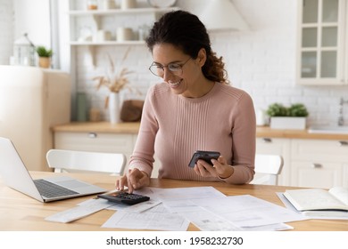 Young latina female work with financial papers at home count on calculator before paying taxes receipts online by phone. Millennial woman planning budget glad to find chance for economy saving money – Stockfoto