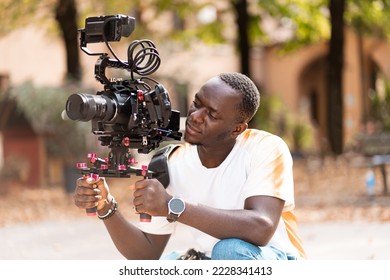 Young man filming with a professional camera outside in the open air Foto stock