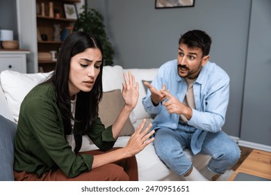 若い夫婦の夫と妻は、彼らの結婚と冷たい関係に問題を抱えて家に座っています。彼氏と彼女のルームメイトは、お金を使いすぎると言い争っているの写真素材