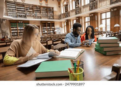 Young people studying in the library and looking involved 庫存照片