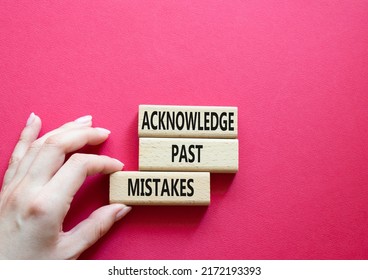 Acknowledge Past Mistakes symbol. Wooden blocks with words Acknowledge Past Mistakes. Beautiful red background. Businessman hand. Business and Acknowledge Past Mistakes. Copy space Arkistovalokuva