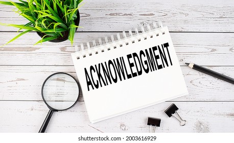 ACKNOWLEDGMENT text concept write on notebook with office tools on the wooden background Arkistovalokuva