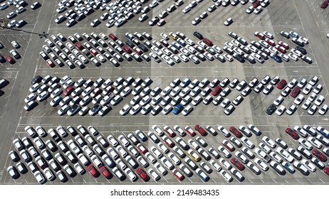 Aerial view of new cars parked in car parking lot. Car dealer parking lot full of new automobiles. New cars lined up for import and export business - green revolution and electric car no fuel and gas  库存照片
