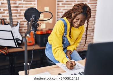 African american woman musician composing song at music studio Stockfotó