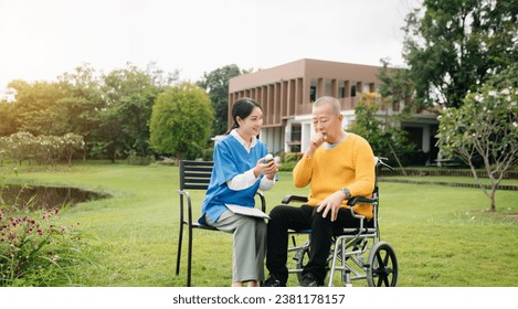 Asian young caregiver nurse support senior older male walking outdoors. Specialis doctor help and take care of elderly mature. Nursing home hospital garden concept.

 库存照片
