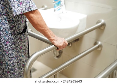 アジアの高齢女性の患者は、バスルームのトイレのサポートレール、手すりの安全グラブバー、介護病院のセキュリティを使用しています。
