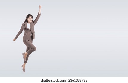 Asian middle-aged business woman in a suit jumping energetically. Foto stock