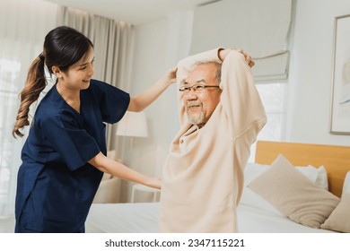 Asian nurse woman assisting old man warming up exercises for the upper body inside the nursing home, use walker with strong health and Help and care concept Foto Stock