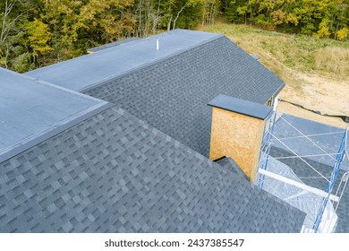An asphalt shingle roof covers roof of newly built house Foto stock