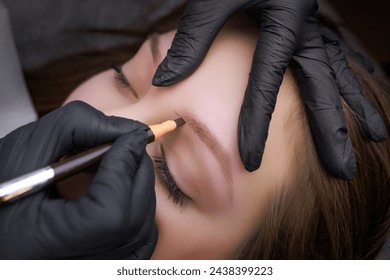 恒久的な化粧の手順の前に、眉毛の輪郭に鉛筆でマーキングを適用します。PMU手順、永久的な眉毛の化粧。の写真素材