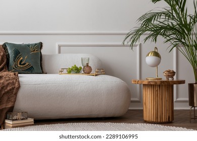 Art deco composition of living room interior with boucle sofa, plant, wooden coffee table, gold lamp, green pillow, elegant trace with glass, grape and personal accessories. Home decor. Template. Stock Photo
