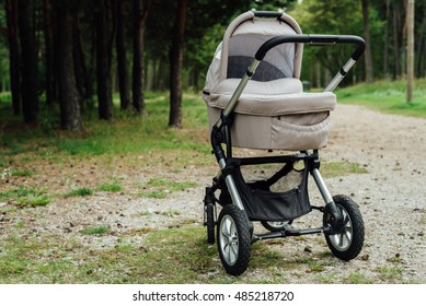 Baby stroller in forest at sunny day Stock Photo
