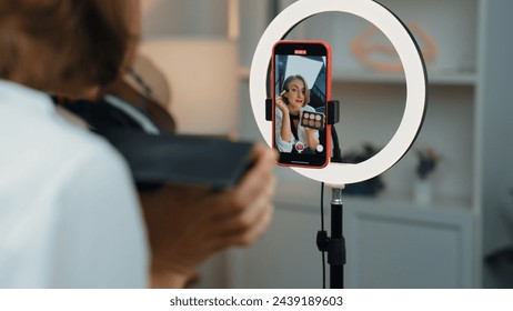 Back view influencer shoot live with smartphpone streaming using vlog video review makeup prim social media or blog. Girl with cosmetics studio lighting for marketing recording session online.: stockfoto