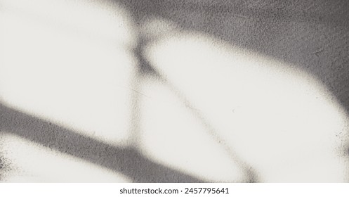 Background image of a wall with shadows from a window cast by the afternoon sunlight, creating a warm and serene ambiance. Foto Stock