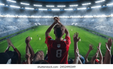 サッカー選手権の試合中にスタジアムでチームを応援するファンの背景画像。チームプレイ、ファンの群衆は勝利と目標を祝う。トリビューンで拍手するサポーターとのサッカーカップトーナメントの写真素材