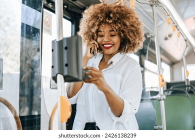 Beautiful black woman using ticket machine and paying contactless for bus or tram. Modern city lifestyle and public transportation concept. – Ảnh có sẵn