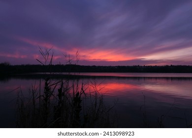 Beau ciel rose et bleu au lever ou au coucher du soleil. Vue sur un lac dans un paysage idyllique. : photo de stock