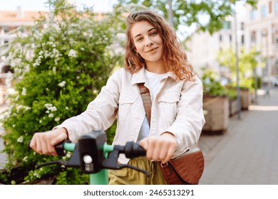 Beautiful woman rides an electric scooter in the city street on a sunny day. Ecological transport. Active lifestyle. – Ảnh có sẵn