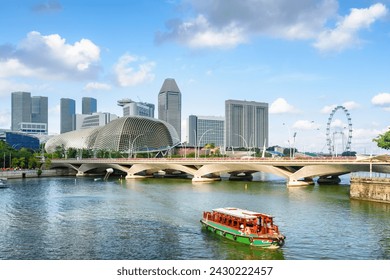 Beautiful view of traditional tourist boat sailing along Marina Bay with azure water in Singapore. Amazing modern buildings are visible on blue sky background. Scenic summer cityscape. Stock fotografie