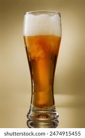ビール。新鮮で冷たいビールのガラス。金色の背景にクラフト金色のビールを注ぐ。 浅い被写界深度の写真素材
