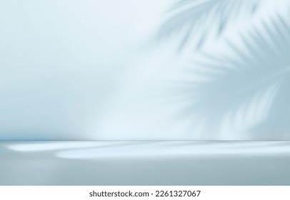 Blurred shadow from palm leaves on the light blue wall. Minimal abstract background for product presentation. Spring and summer. Foto Stock