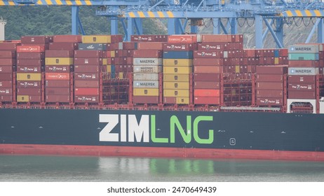 Busan, South Korea - 10.01.2023: ZIM Mound Denali LNG fuel powered vessel has cargo operations in container terminal of port New Busan in stead of living buildings of Busan city , fotografie de stoc Editorial