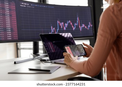 Femme d'affaires examinant un graphique sur un smartphone au bureau : photo de stock