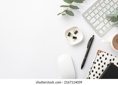 Business concept. Top view photo of workplace keyboard computer mouse black and white trendy note pads pen binder clips cup of coffee and eucalyptus on isolated white background Stockfoto