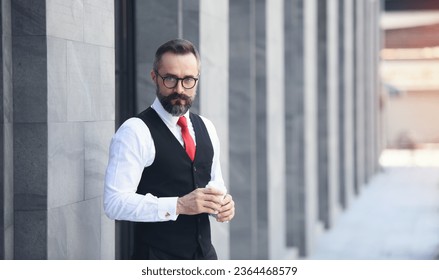 ビジネスマンのポートレート。自信を持って成功し、ビジネスマンやマネージャーは、白いシャツで彼の職場の近くに手にコーヒーカップを保持しますオフィススペース屋外、直接カメラで見えます。の写真素材