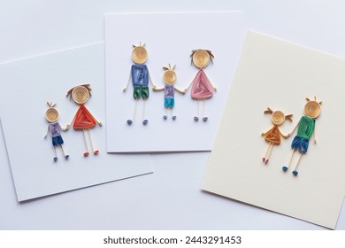 Cards with Happy family with father, mother and kid holding hands together. family stick figure. parents and children. Hand made of paper quilling technique. handicraft at home, card craft Stock-foto
