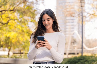 caucasian woman smiling happy using her mobile phone, concept of technology of communication and modern lifestyle, copy space for text Stockfoto