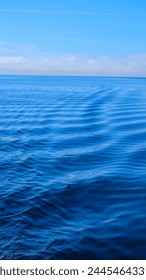 Chonchi, Isla Chiloe, Chile - 10 de febrero de 2020 - Foto de olas en un mar azul muy tranquilo en un día claro y brillante.  Foto de stock