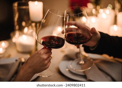 Cheers. Couple in love drinking wine. Romantic date by candlelight at night. Hands man and woman hold glasses at home. Toast. Dinner setup table for couple on Valentine's day. Proposal hand and heart. – Ảnh có sẵn